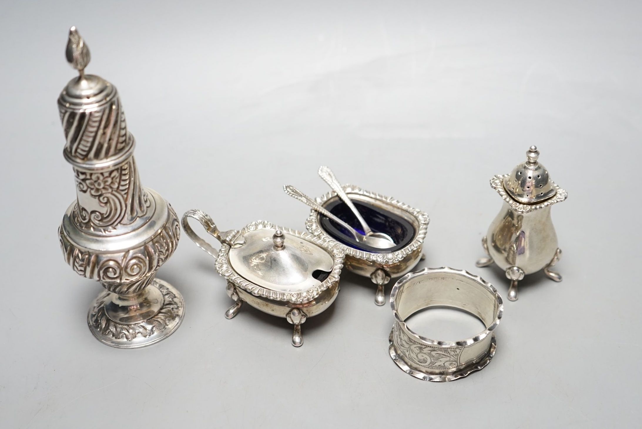 An Edwardian silver sugar sifter, Birmingham, 1901, a silver three piece condiment set and a silver napkin ring.